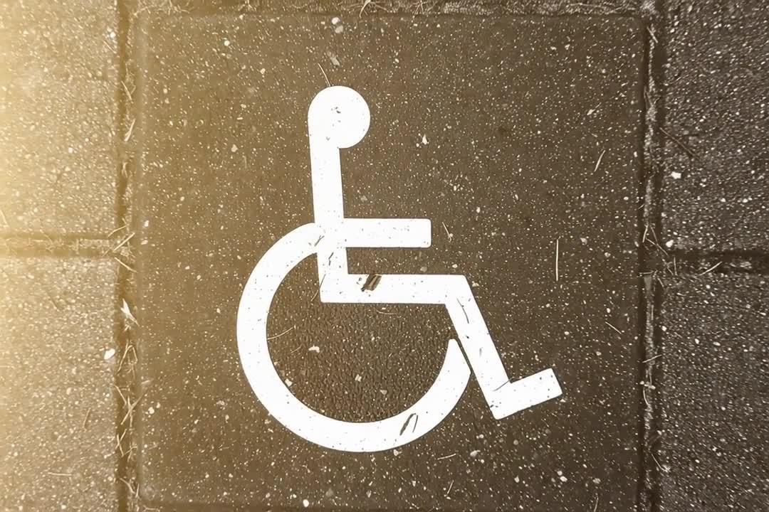 Symbol dostępności dla osób na wózkach inwalidzkich na chodniku